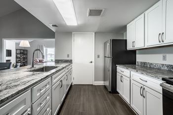 A modern kitchen with white cabinets and a black refrigerator